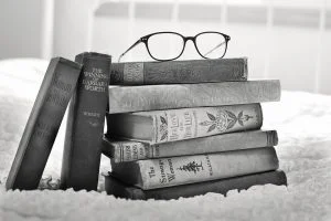 A pair of glasses on top of a pile of books